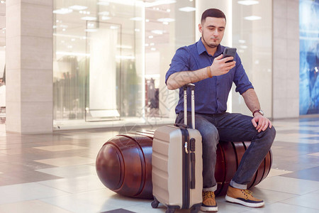 机场有智能手机和手提箱的商人在登机前检图片