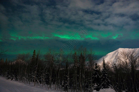 白雪皑的夜山云背后的北极光图片