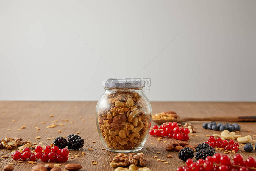 有选择地将颗粒的罐子加坚果燕麦片浆果和谷条放在以灰色隔开图片