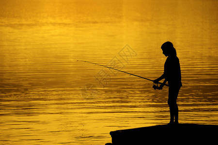 日落娱乐趣时在湖或河中捕鱼图片