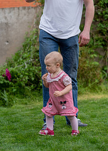 爸气方刚小孩1岁的女婴去父亲带着孩子穿过绿草婴儿在父母的支持下学会走路1岁的女孩和爸生活方背景