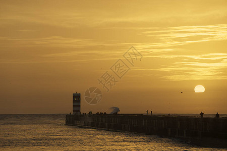 多罗河口南码头和灯塔的橙色日落图片