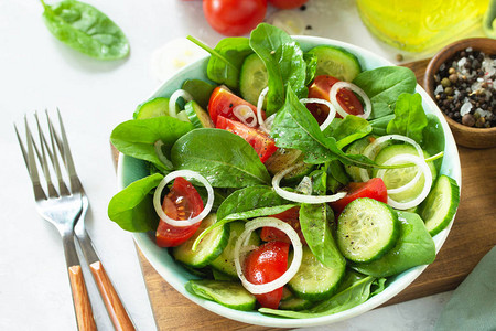 新鲜番茄黄瓜洋葱和菠菜的蔬菜健康沙拉图片