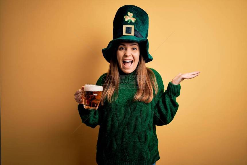 戴着绿帽喝啤酒的年轻美女非常高兴和奋图片