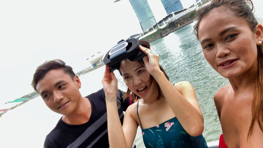快乐的亚洲人户外使用虚拟现实眼镜享受城市生活图片