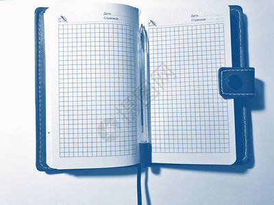 笔与白色背景上的笔记本彩通蓝经图片