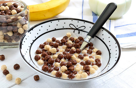 白色木质背景上的全麦巧克力和牛奶球水果茶和牛奶健康的麦片早餐婴儿早餐宝吃东图片