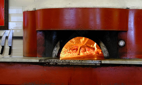 在红披萨烤箱中燃烧的火图片