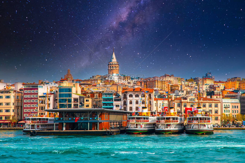 土耳其伊斯坦布尔市的加拉塔土耳其伊斯坦布尔市与博斯普鲁斯海峡海鸥和船只在明亮的天空和日落图片