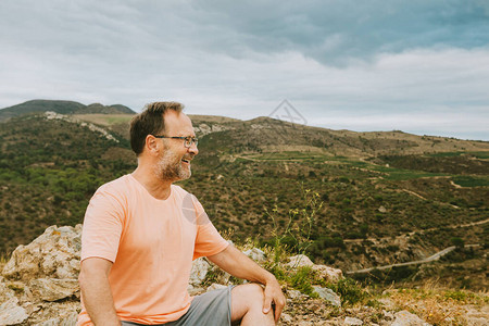 英俊的中年男子在山顶冥想放松的户外肖像图片