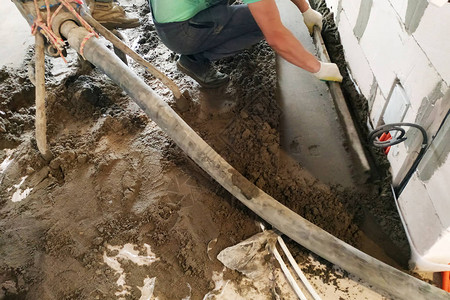 雇员从事沙水泥地板的铺垫砂水泥地板的盖子供取暖高清图片