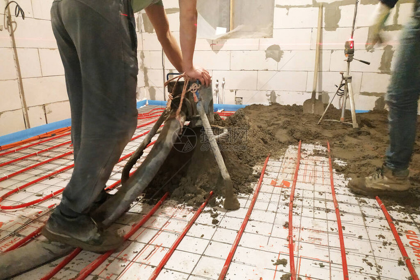 在新建造的房屋中工人用沙水泥铲子取暖图片