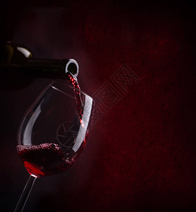 红酒从瓶子里倒在酒杯里图片