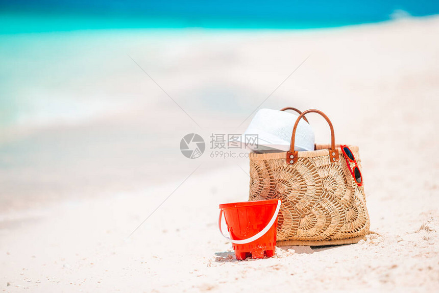 白沙滩上的海滩袋草帽图片