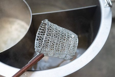 热面锅上的传统泰式钢丝网面过滤器特写图片