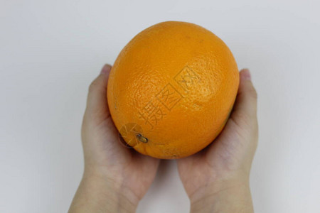 孩子的手握着熟橙子图片