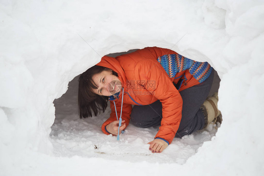 可爱的小caucasian小男孩铲雪在院子里的雪和firtr图片