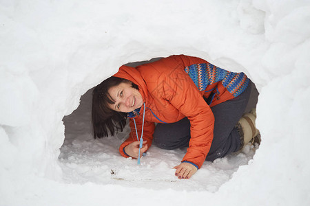 可爱的小caucasian小男孩铲雪在院子里的雪和firtr图片