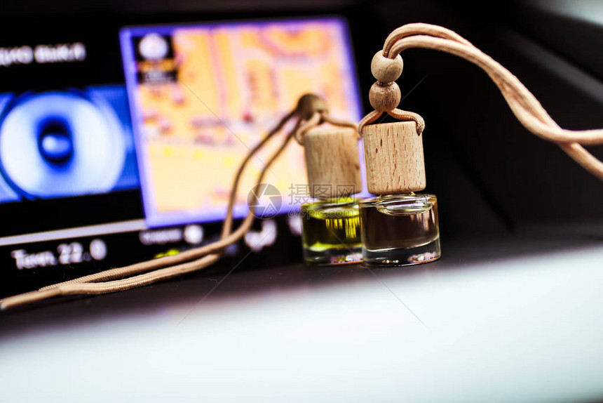 车内汽车空气香水清新剂瓶与汽车仪表板的一部分带有木盖和芳香液图片