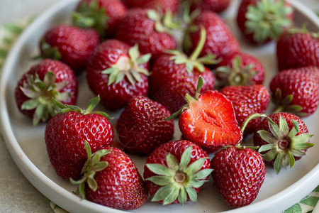 粘土板中成熟的多汁草莓在光背景和复印薄图片