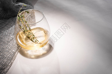 透明玻璃有草药冰块和威士忌在白桌上图片