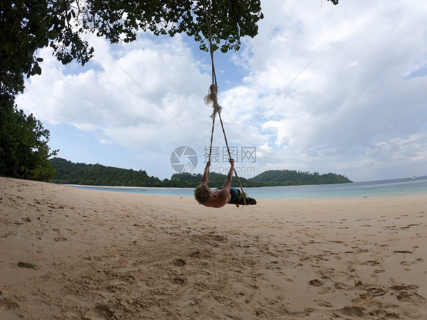 活跃的男孩在泰国享受海滩摇摆图片