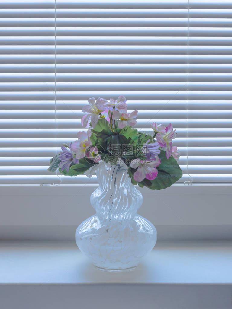 透明玻璃花瓶窗台上有人工花朵图片
