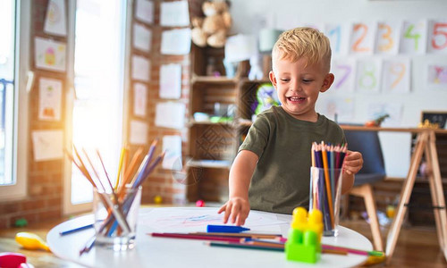 幼稚的天主教儿童在幼儿园用彩色铅笔绘画图片