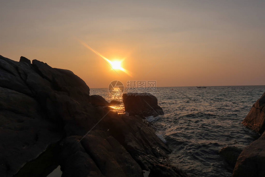 太阳在海洋中反射以及海浪冲向悬崖和岩石的波浪pos191图片