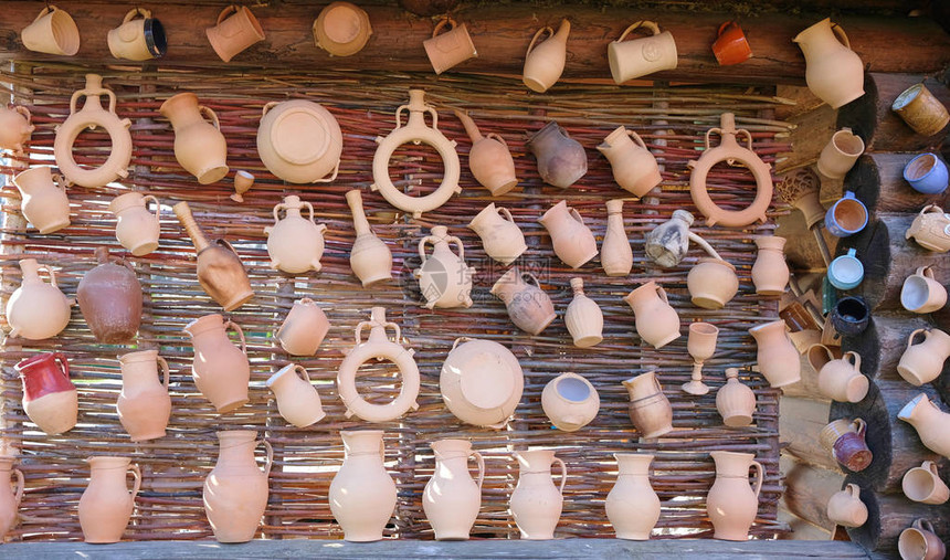 有许多陶器和水罐的柳条墙壁图片