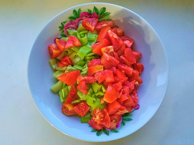 白蓝盘顶视图中的黄瓜番茄胡椒自制红绿色沙拉图片