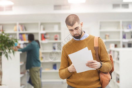 站在大学图书馆复制空间的成人留胡子大胡子学生持有论图片