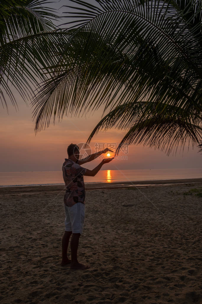 在泰国Chumphon地区海边看日落的人图片