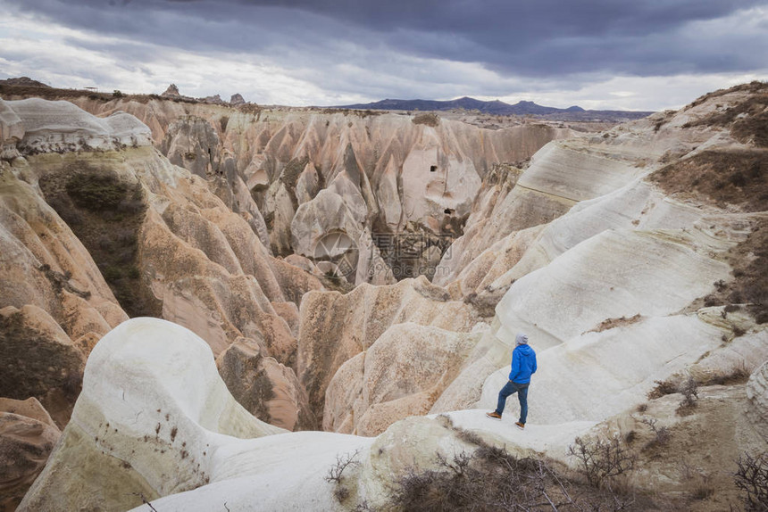 人在Kapadokya看向遥远的戏剧喜怒无常的山谷背景是岩石地质构造探索有趣的地质图片