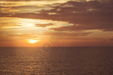 海面上美丽的日落太阳落在地平线后面图片