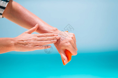 女人在热带海滩上晒太阳用防晒霜洗手图片