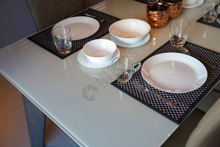 白色餐盘套餐桌安排在现代内地客房的图片