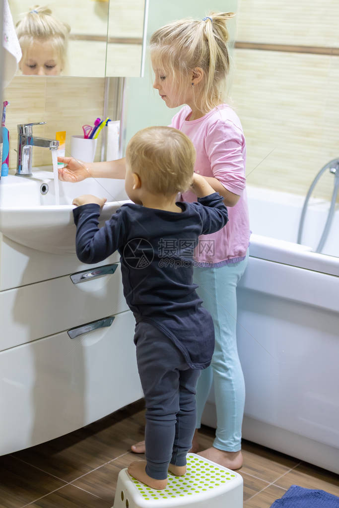 两个可爱的金发白人兄弟姐妹早上在家里的浴室里用牙刷洗脸和刷牙小孩子兄弟姐妹每天做higyene保健图片