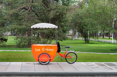 冰淇淋橙色卡车绿色城市公园树背景温暖阳光明媚图片