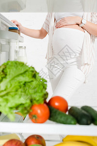 在白底新鲜蔬菜和水果的露天冰箱附近图片