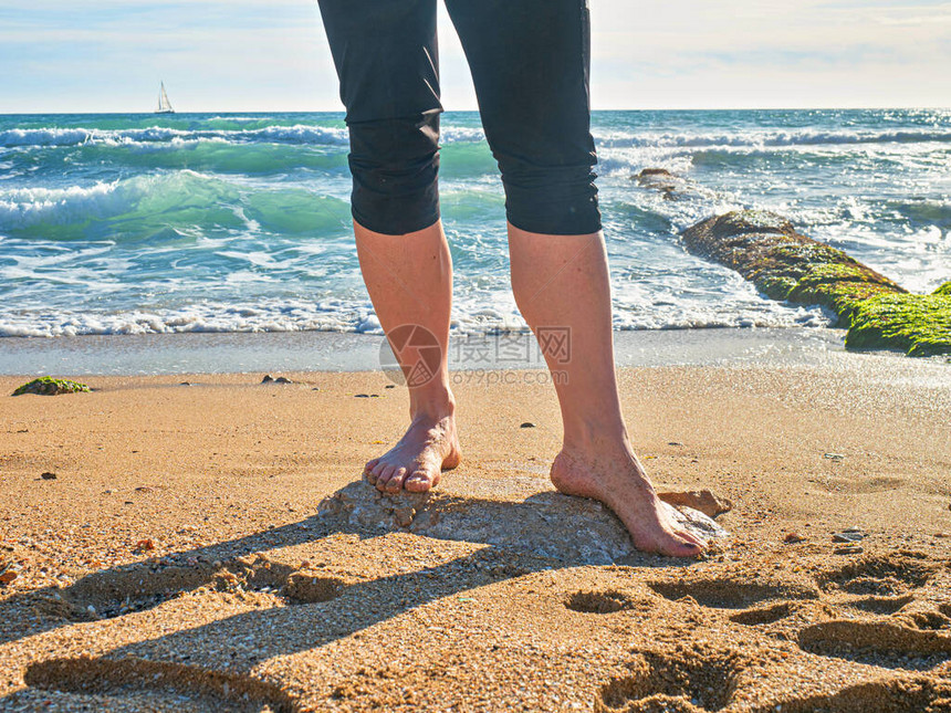 女孩在海边的湿沙滩上留下脚印女孩在狂图片