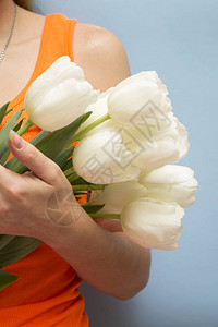 一个女人手里拿着一大束白色的郁金香Prikark母亲节妇女节情人节与图片