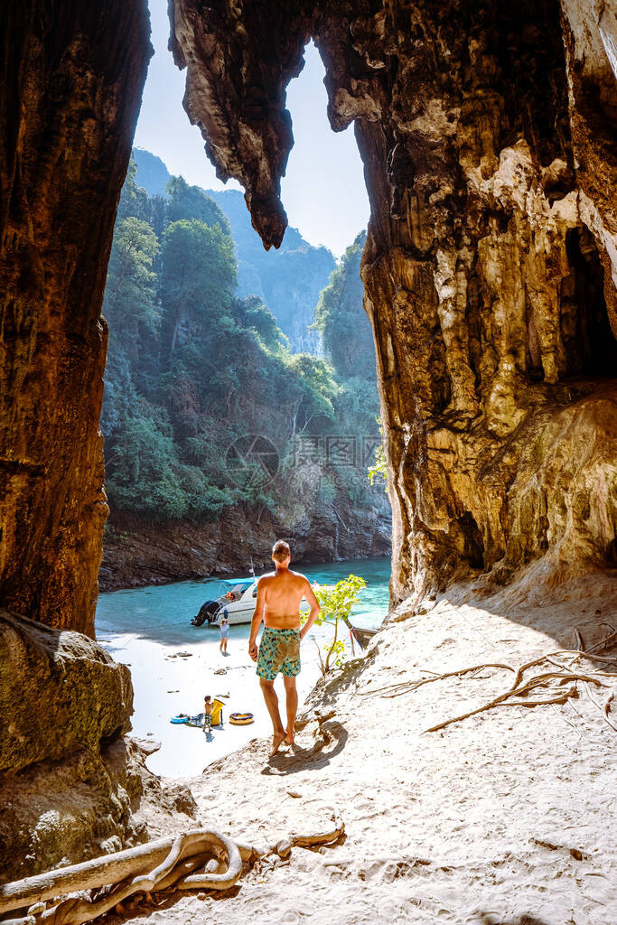 在石灰岩悬崖上的人看着在泰国KohPodaKrabi的沙滩图片