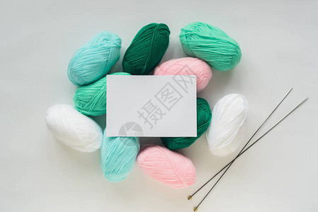 针织丙烯酸软柔和彩色羊毛纱线束堆和白色背景上的针白纸背景图片