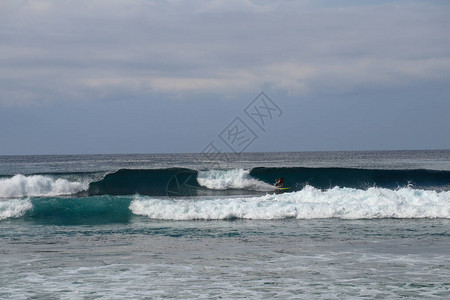 印度尼西亚巴厘岛冲浪者骑桶波在阳光明媚的日子里背景图片