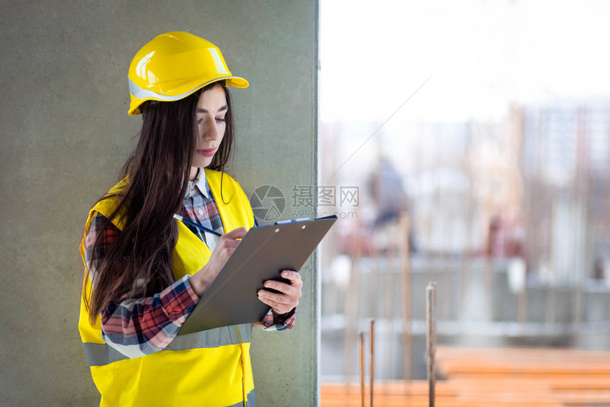 手持剪贴板的女建筑工人检查施工过程图片