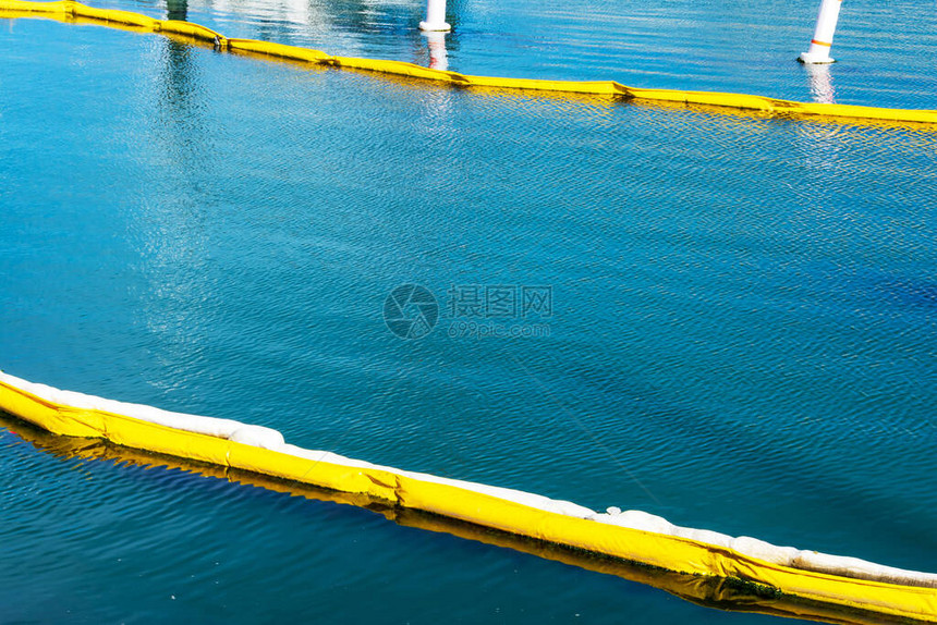 漂浮在平静水面上的黄色和白色油封围油栏污染概念围油栏是用于控制漏油的图片