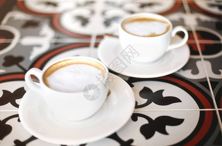 咖啡厅装饰瓷砖桌上的碟子上放着新鲜拿铁的杯子图片
