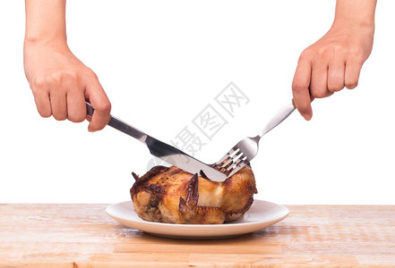 烤鸡被刀和叉在白背景孤立的木桌上图片
