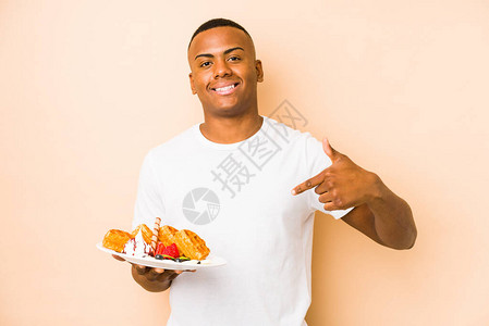 年轻拉廷男子拿着一个华夫饼孤立的人图片